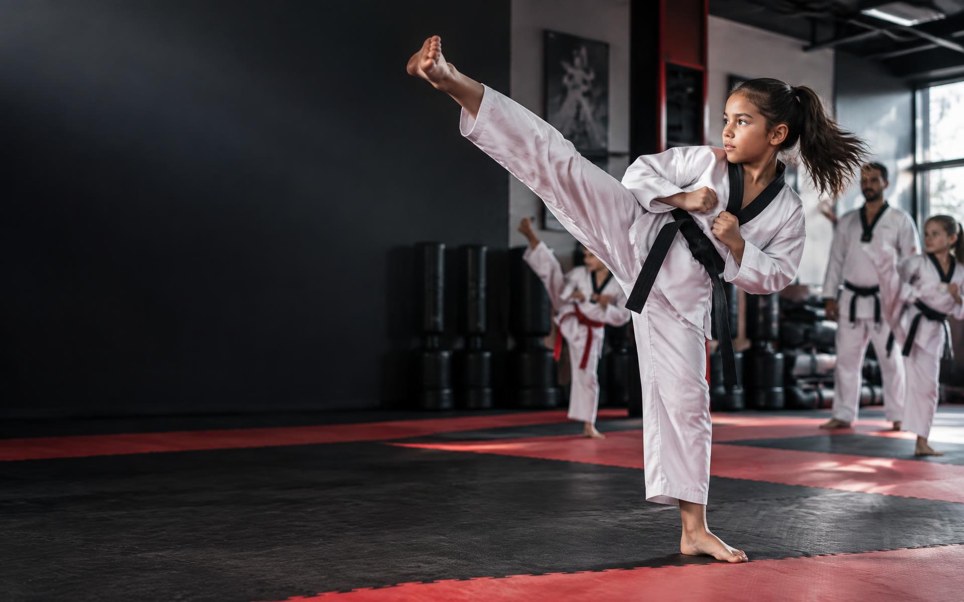 Young martial arts student practicing a high kick
